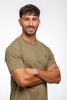 Pola Plano Medio Pola de plano medio de un actor con barba y brazos cruzados, sonriendo con confianza en un estudio fotográfico.