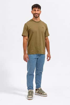 Pola plano general Foto de cuerpo entero para pola profesional de un modelo masculino de pie, con camiseta y jeans, sobre fondo blanco.